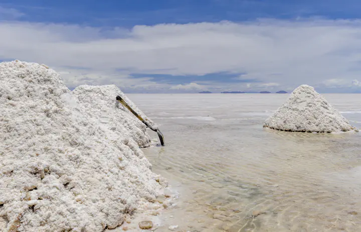 Des monticules de sel récolté émergeant d'eaux peu profondes sur le Salar de Uyuni près de Colchani, Bolivie.