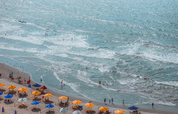 Parasole plażowe i pływacy wzdłuż wybrzeża Cartageny w Kolumbii