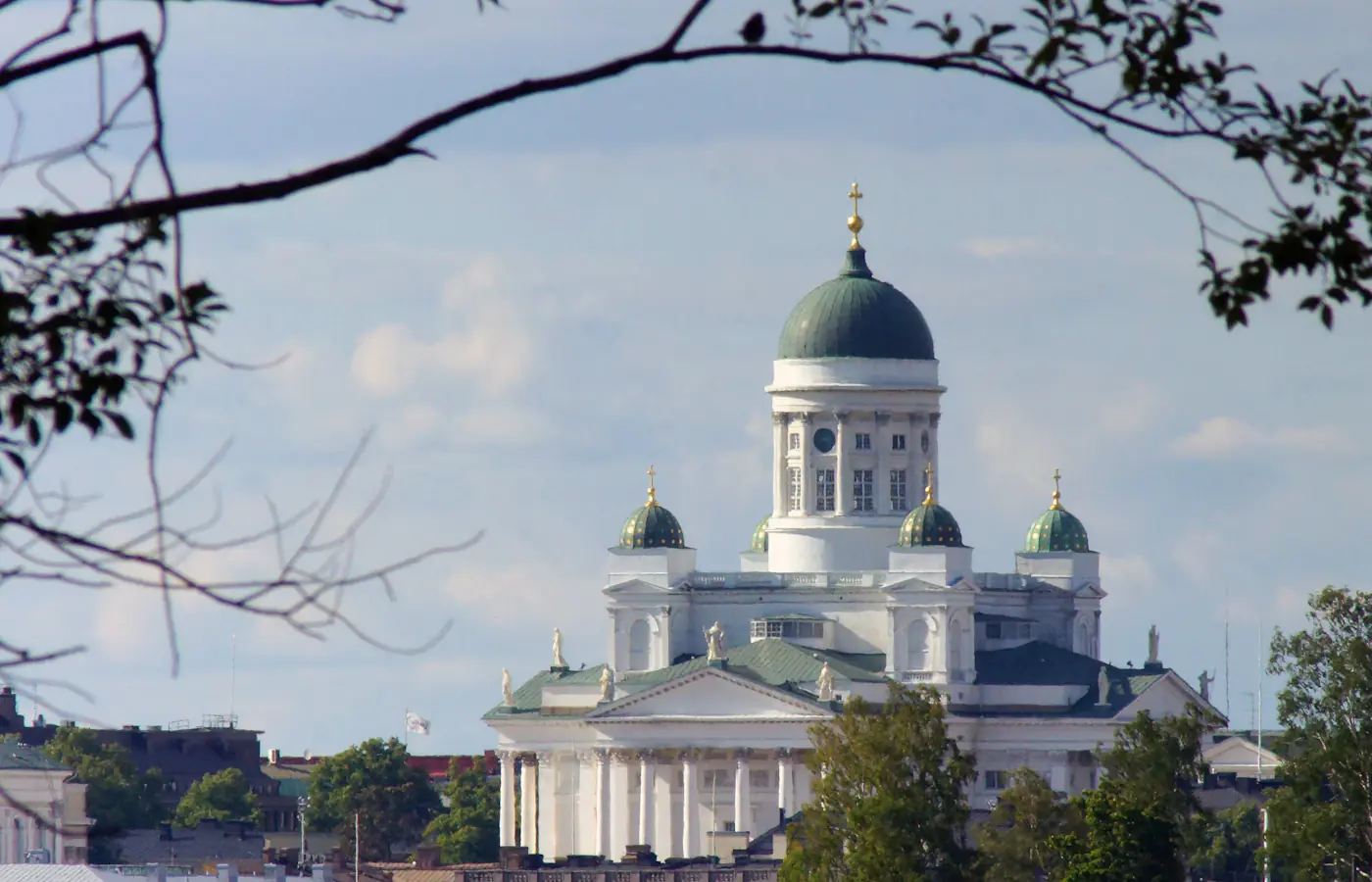 Der Dom von Helsinki mit seiner grünen zentralen Kuppel, eingerahmt von Baumzweigen in Finnland