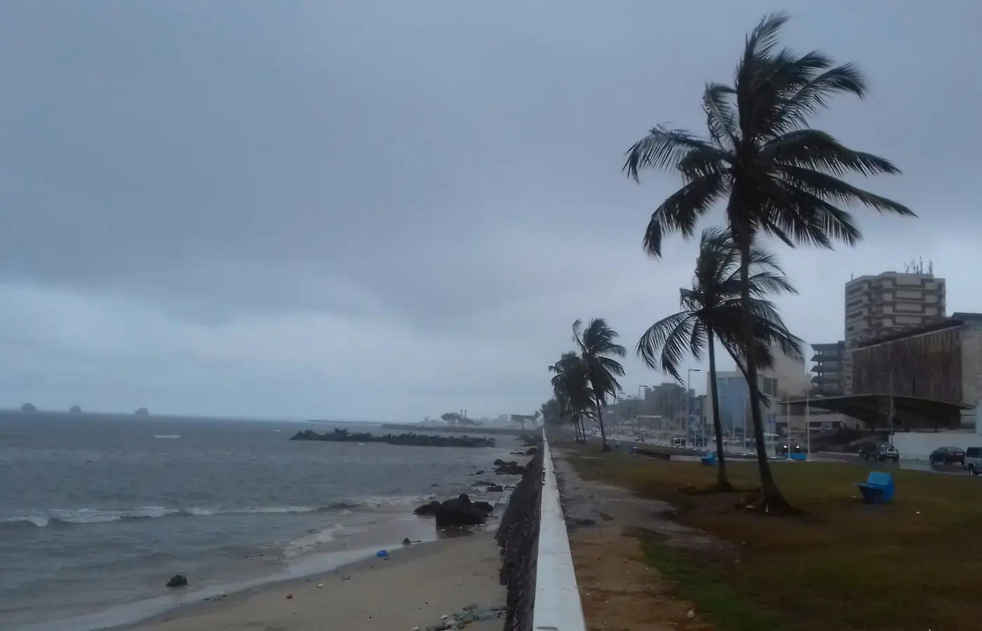 Palmiers et promenade en bord de mer à Libreville, Gabon, sous un ciel couvert