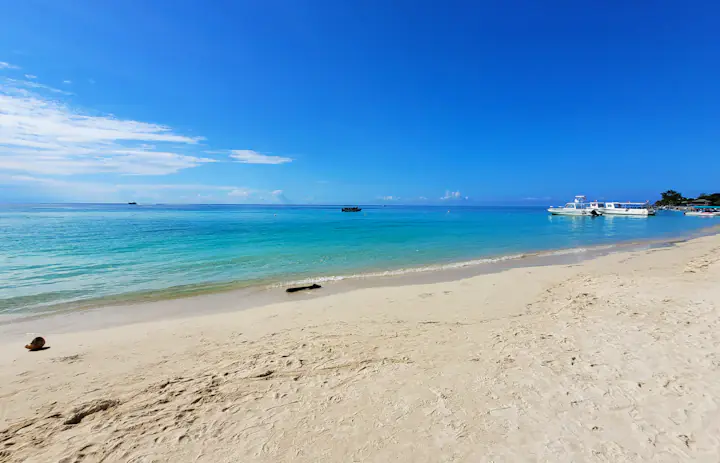 Areia branca, água turquesa e barcos atracados em West Bay, Roatán, Honduras