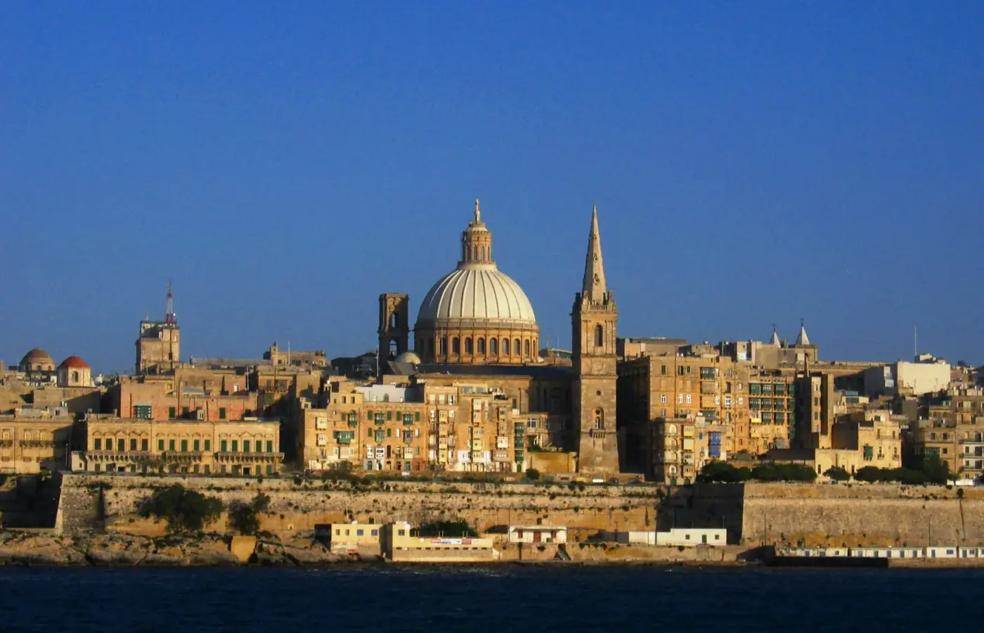Die Uferpromenade von Valletta mit der Kuppel der Basilika Unserer Lieben Frau vom Berge Karmel und der Spitze der St. Paul's Pro-Cathedral