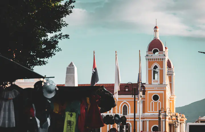 Granada cathedral with its yellow tower and market stalls in Nicaragua