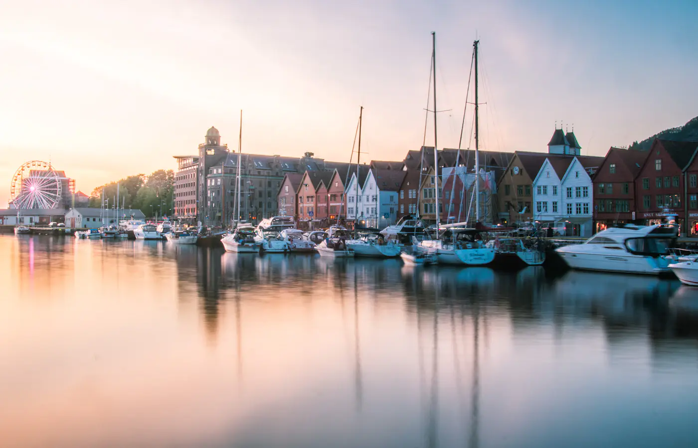 Barcos e casas pintadas à beira-mar ao longo do cais Bryggen em Bergen, Noruega
