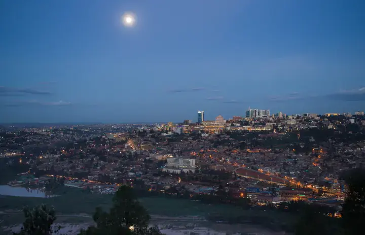 Evening skyline of central Kigali with hillside lights under the moon, Rwanda.