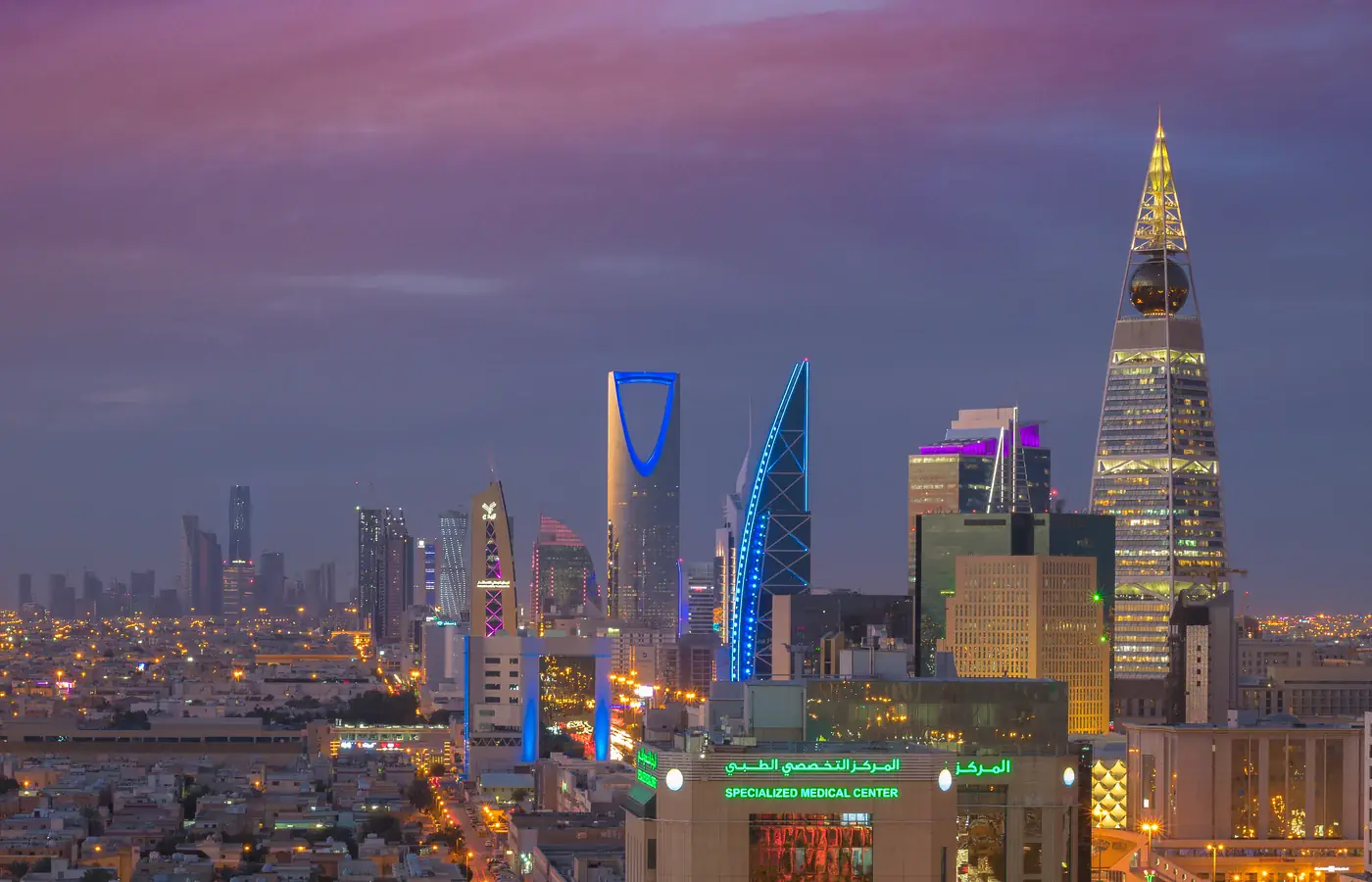 Skyline de Riade ao anoitecer com o Kingdom Centre e a Al Faisaliah Tower iluminados