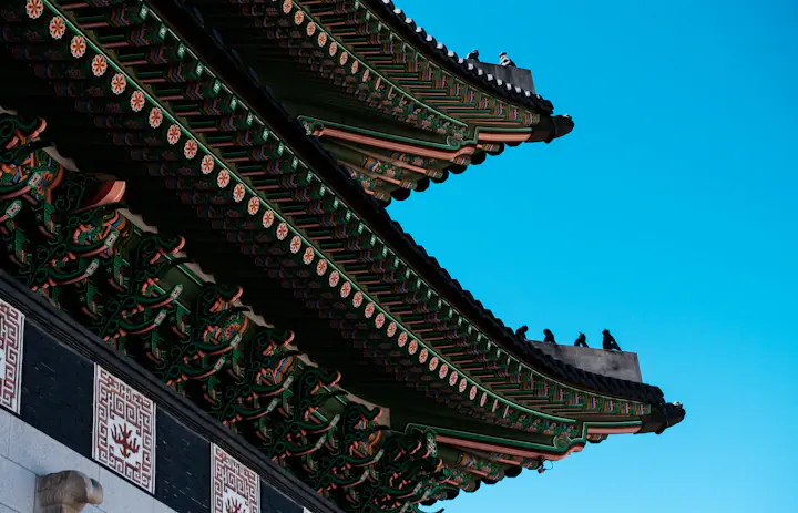 Beirais ornamentados do telhado do palácio sob um céu azul em Gyeongbokgung em Seul, Coreia do Sul