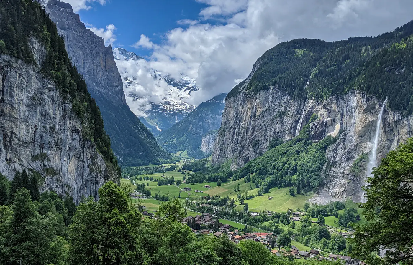 A waterfall cascading over cliffs into the green meadows of the Lauterbrunnen valley, Switzerland